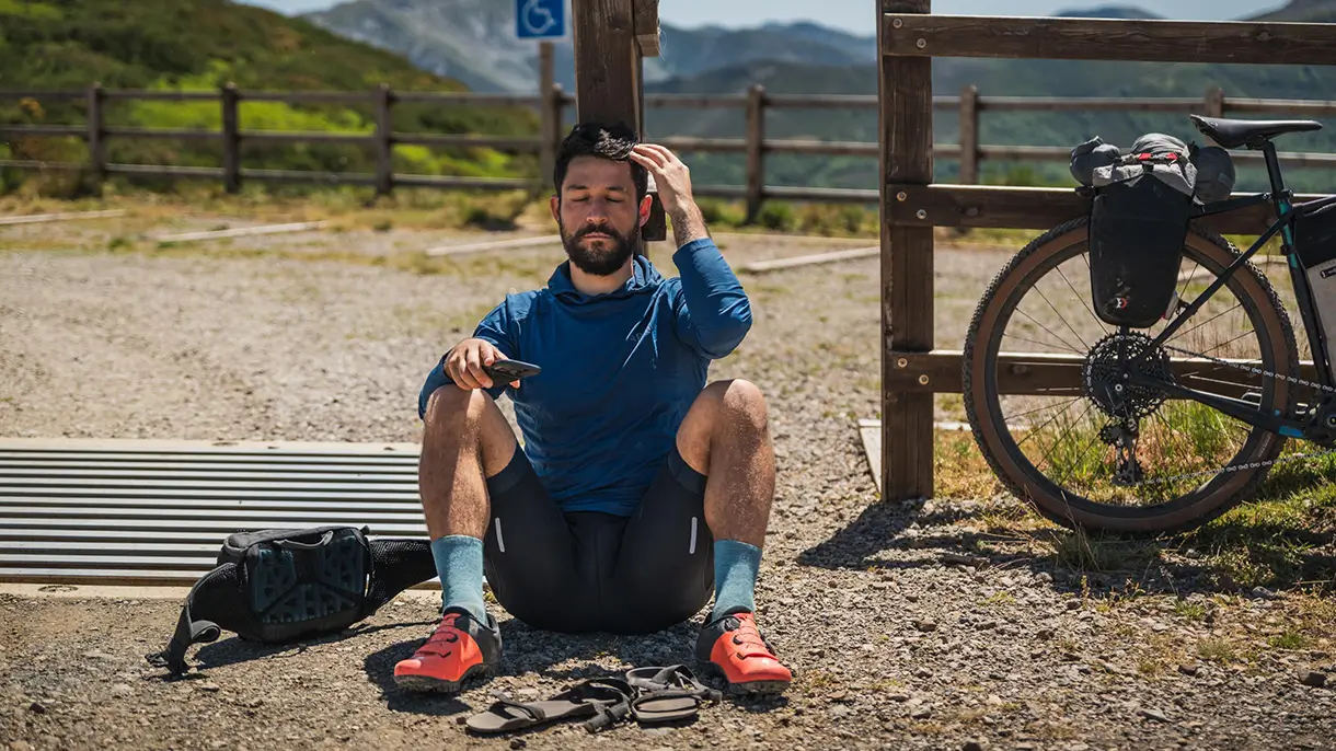 Sedící a relaxující cyklista v horách